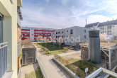 Blick vom Balkon auf die Wohnanlage - Moderne 2-Zimmer-Eigentumswohnung mit Balkon und TG-Stellplatz