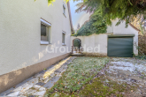 Gebäuderückseite mit Garage - Siedlerhaus mit Potential: gepflegtes Einfamilienhaus mit Garage und Garten in Nürnberg